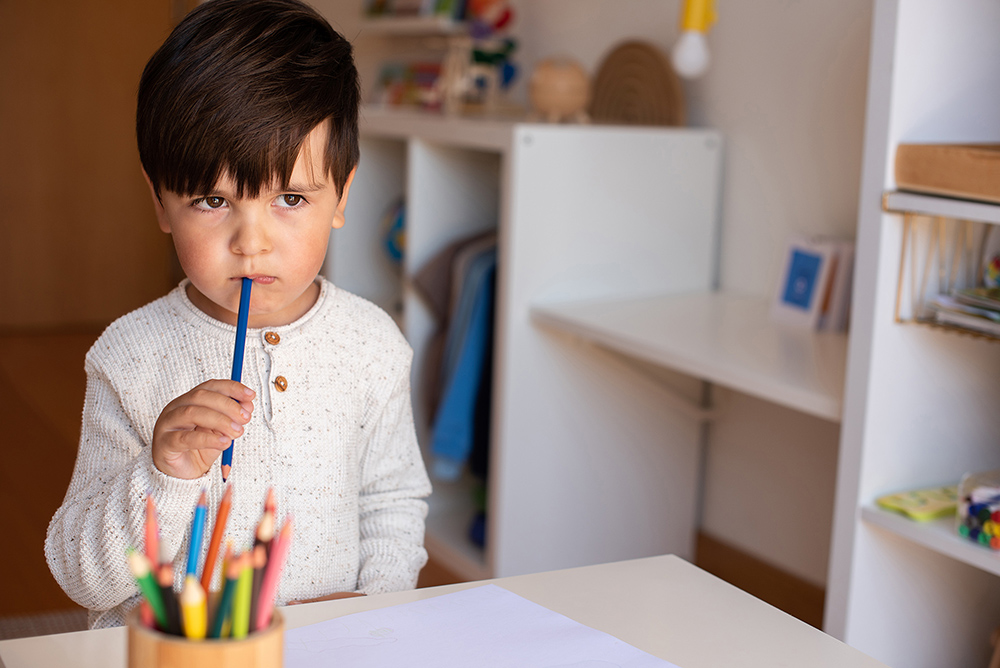 Preschooler kid drawing with coloured pencils. Homeschooling